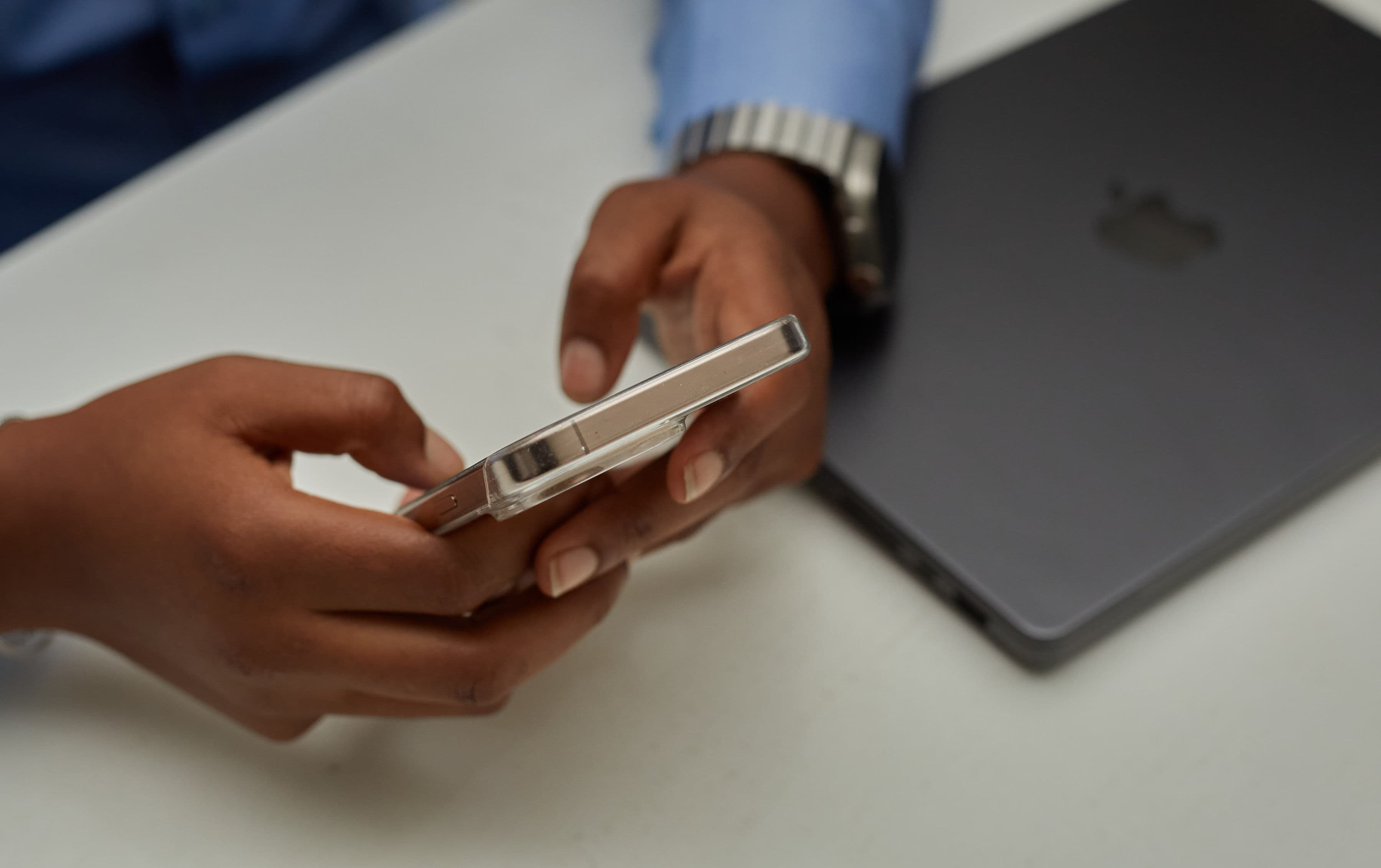 Person using a smartphone at a desk, representing ways to reach the Chiggy Nsofor Foundation